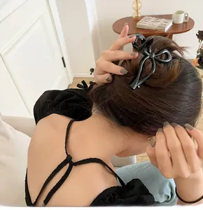 Elegante pinza per capelli grande con fiocco nero indossata su un'acconciatura a chignon