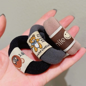 Three-piece teddy bear hair scrunchies set in black, gray, and brown elastic fabric