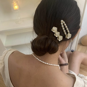 Elegant camellia flower hair clip and pearl necklace set on female model back view