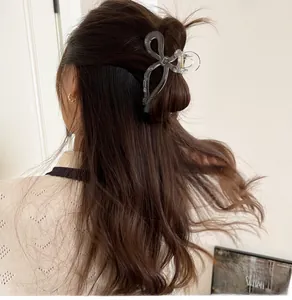 Dettaglio di una grande pinza per capelli a fiocco trasparente su capelli castani