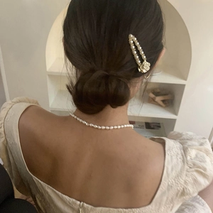Elegant camellia hair clip and pearl necklace set worn by model for a vintage chic look