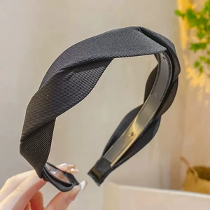 Detail view of black braided twist headband with anti-slip teeth and twill fabric texture