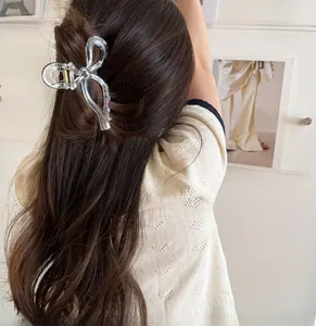 Vista dettagliata della clip per capelli a fiocco trasparente su capelli mossi castani