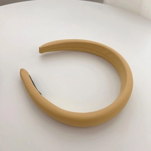 Detail view of khaki sponge headband featuring fine textured fabric and anti-slip lining