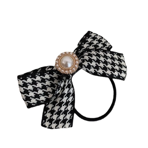 Houndstooth bow hair tie with pearl rhinestone detail on a white background