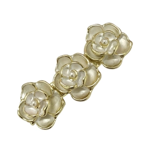 Elegant cream camellia hair clip with gold edges and pearl accents on white background