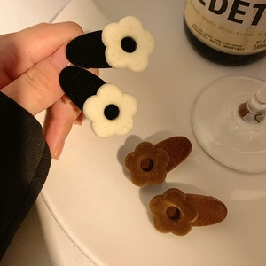 Macro detail of French vintage velvet flower hair clips in black and brown velvet finish
