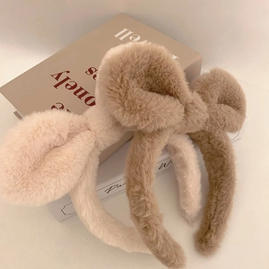 Detail von flauschigen Schleifen-Stirnbändern in Creme und Hellbraun aus Plüsch