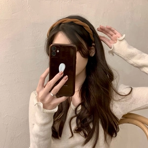Serre-tête tressé en velours marron sur mannequin pour un style de coiffure minimaliste