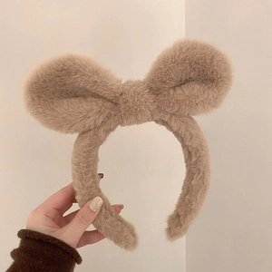 Details des flauschigen khakifarbenen Stirnbands mit großer Schleife und weichem Pelzimitat