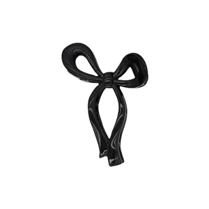 Pinza per capelli a fiocco nero lucido per uno styling elegante su sfondo bianco