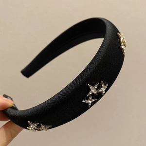 Detail of black padded satin headband with sparkling gold star rhinestone embellishments