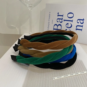 Détail de bandeaux tressés en velours coloré en marron, vert, bleu et noir élégant