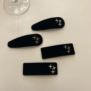 Detail of black velvet hair clips with silver star rhinestones in various geometric shapes