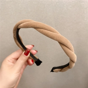 Gros plan d'un serre-tête en velours kaki avec un design de tresse torsadée