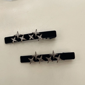 Detail view of black velvet hair clips with sparkling rhinestone star-shaped decorations