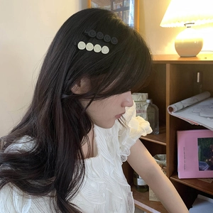 Set of two minimalist smile face hair clips in black and beige on long wavy hair