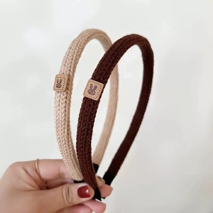 Knitted beige and brown thin headbands with rabbit patches in a clean minimalist style