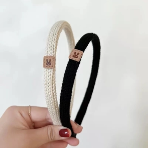Detail of knitted headbands in beige and black with cute brown leather rabbit patches