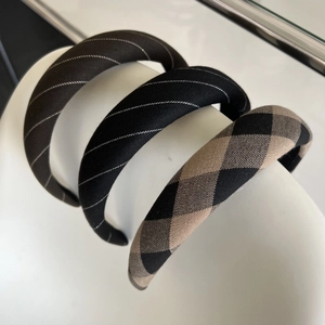 Detail of three thick vintage plaid headbands in dark brown, black, and checkered fabric