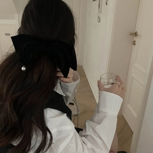 Pince à cheveux élégante en velours noir avec pendentif perle sur un mannequin