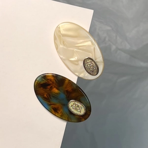 Lot de barrettes ovales en acétate marbré crème et écaille de tortue avec logo métal