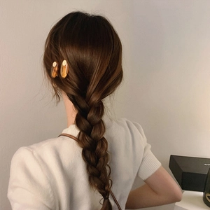 Amber acetate oval hair clip and metal pin set worn on model with dark brown braided hair