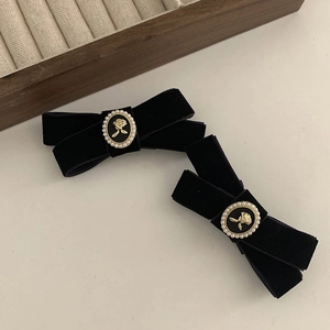 Detail of vintage black velvet bow hair clips with rose relief pearl center ornament