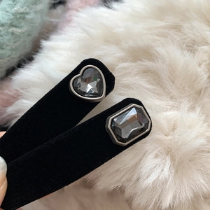 Detail of two black velvet hair clips with grey heart and square faceted rhinestones