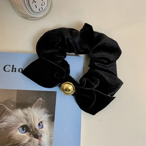 Elegant black velvet bow scrunchie with a gold metal button for a retro ponytail look