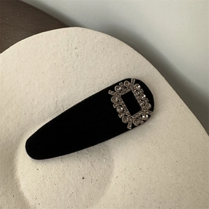 Détail de la barrette vintage en velours noir ornée d'une boucle carrée en strass