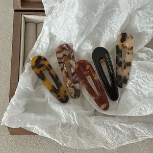 French retro acetate hair clips in leopard and marble patterns with gold lettering