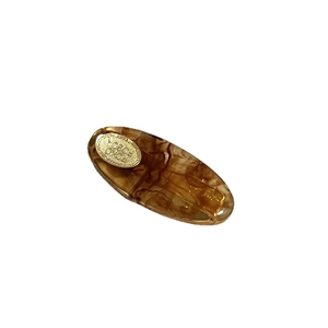 Oval acetate hair clip with tortoiseshell texture and gold metal plate embellishment