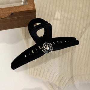 Close-up of black flocked camellia hair claw clip with pearl center and golden edges