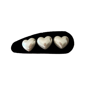 Vintage velvet hair clip featuring three silver heart accents on a black fabric base