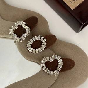 Close-up of vintage rhinestone hair clips with heart and geometric shapes on brown flocking