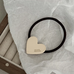 Dettaglio dell'elastico per capelli a cuore in acetato con scritta France Handmade