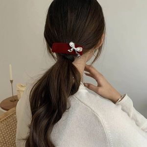 Elegant red velvet BB clip with sparkling rhinestone bow on a low ponytail style