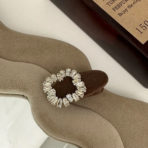 Macro view of the baguette-cut crystal rhinestones on a round hair clip accessory