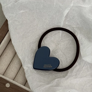 Dettaglio di elastico per capelli a cuore in acetato blu con scritte dorate France