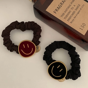 Detail van elastische fluwelen haarelastiekjes met gouden smiley-bedeltjes