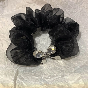 Close-up of black organza scrunchie with silver bow and crystal droplets