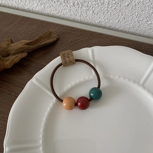 Details des Haargummis mit braunem Gummiband und Harzperlen in Morandi-Farben