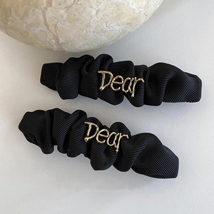 Set of 2 black pleated fabric hair clips with gold metal Dear letter emblem
