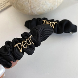 Elegant black woven pleated hair clip featuring gold metal Dear letter ornament