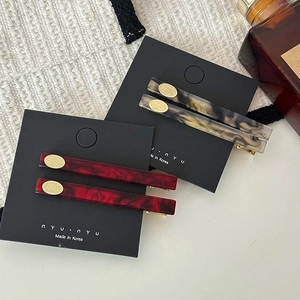 Barrettes à cheveux minimalistes en acétate marbré avec détails dorés chic