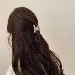 Vista dettagliata di una mini clip per capelli in lana colorata su un'acconciatura