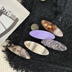 Elegant acetate barrettes in marble and tortoiseshell patterns on tweed fabric
