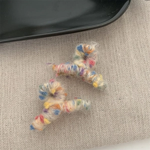 Dettaglio di graziose mollette in maglia arcobaleno con trame colorate per l'autunno