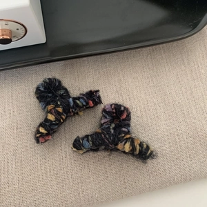 Dettaglio delle mini mollette per capelli in lana colorata con texture a maglia